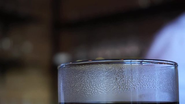 Close up of coffee glass vapor barista appears in the background 