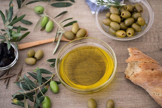 Italian food background with ciabatta bread, olive oil and olives.