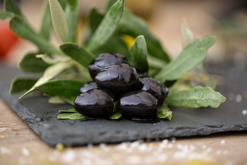 black olives on natural olive tree leaves.