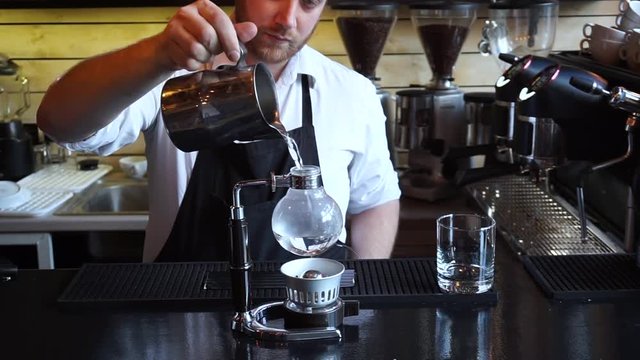Close up barista pouring Syphon coffee into glass in coffee shop