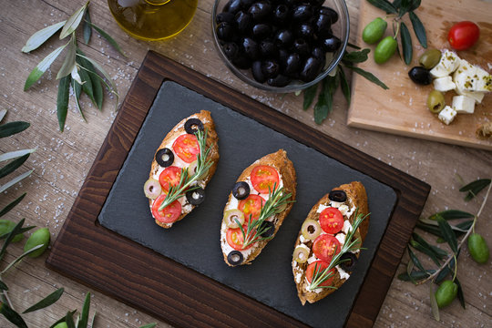 plate of delicious bruschetta on wooden table with fresh vegetables.