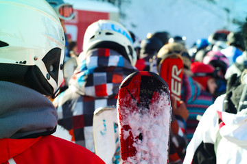 Winter sports: Group of people with skis and snowboards waiting in line