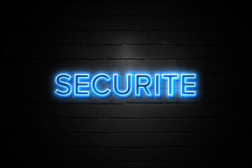Securite neon Sign on brickwall