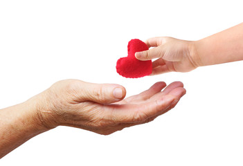 A young hand of a baby giving a red heart to an old hand of the elderly isolated with copy space to add text