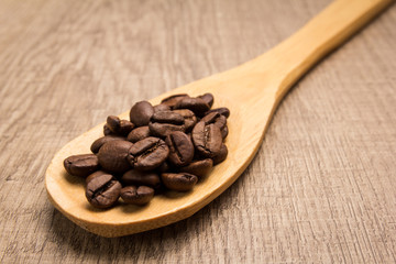 coffee beans seed. Spoon and grains over wooden table.