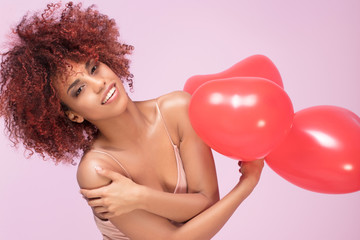 Lovely afro girl with red balloons.