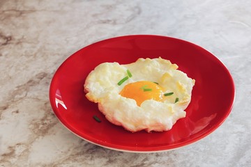 Homemade baked cloud egg served in red plate