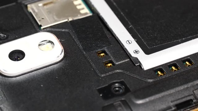 Male human hand putting battery into phone. Smartphone fixing, technology repairing concept.