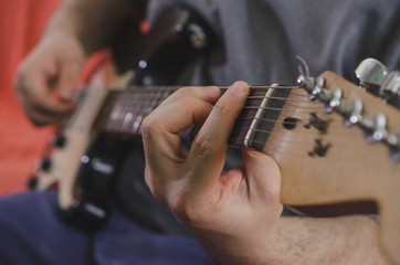 Musician hands playing chords on electric guitar