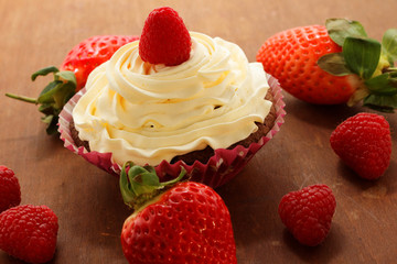 Homemade delicious chocolate cupcakes with fresh raspberry and cream on top. Delicious cupcake for Valentine’s Day. 
