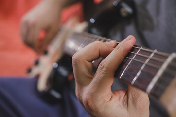 Musician hands playing chords on electric guitar