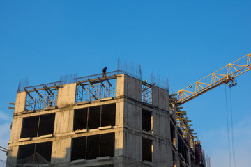 the builder is on the roof of a house under construction