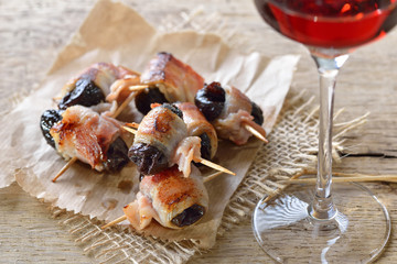 Leckere Tapas: Getrocknete Pflaumen in Speck gerollt und gebraten, dazu ein Glas Old Tawny Portwein – Delicious Spanish tapas:  Fried prunes wrapped in bacon served with Portuguese port wine
