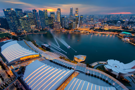 Singapore city skyline. Business district aerial view. Downtown landscape reflected in water at sunset in Marina Bay