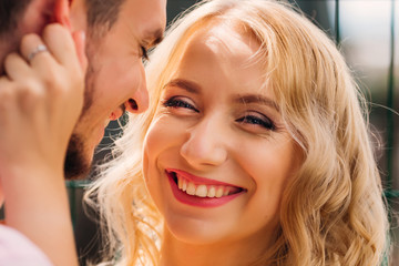 a woman with a pretty face smiles genuinely in the camera lens and the guy next to her