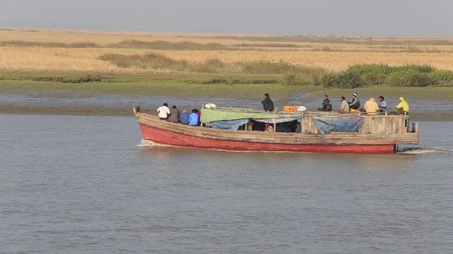 SITTWE, MYANMAR - JANUARY 29, 2016: Unidentified local people in wooden boat on the river water from the town of Mrauk-U to Sittwe during dawn. Burma