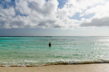 Fototapeta na wymiar Rear view of a man in the turquoise water of Baby Beach, Aruba