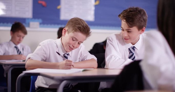 4k, Two secondary school students talking to each other in a class room