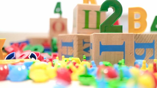 Early development of the child. Close-up shows toys for the development of intelligence.
The frame shows plastic letters, mosaic, cubes with figures