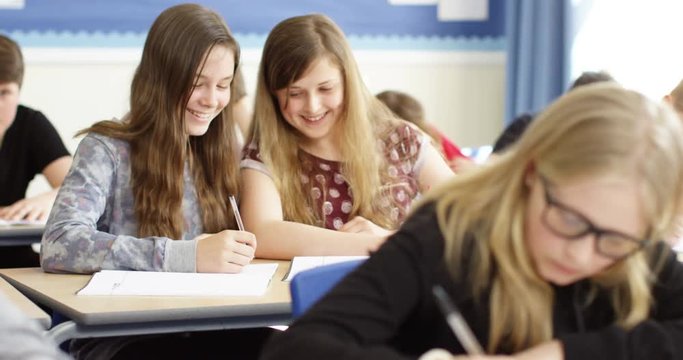 4k, Talkative school girls are caught whispering to each other during a class.
