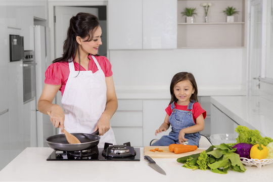 Beautiful woman with child cooking together