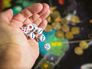 The man does throw six dice on the game Board.