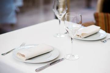 Beautiful table setting, with glasses and utensils.