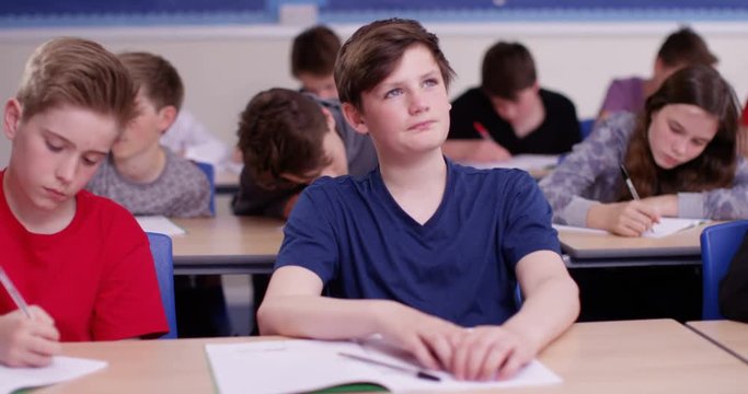 4k, School boy day dreaming beside his classmate in classroom
