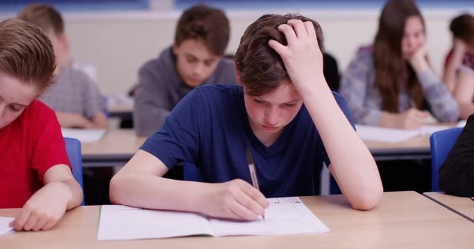 4k, Overworked young student sitting with his head in his hands