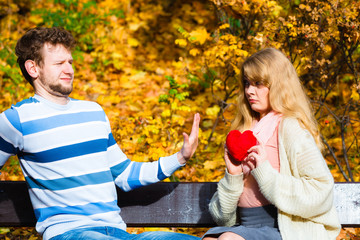 Woman confess love to man on bench in park.