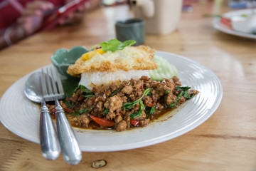Thai popular food Pad Kra Pao with rice and topping with fried egg