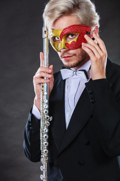 man in carnival mask playing flute