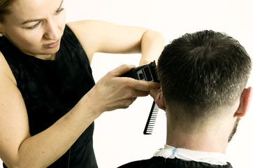 Female hairdresser shaping mens hair cutting uses scissors in a beauty saloon