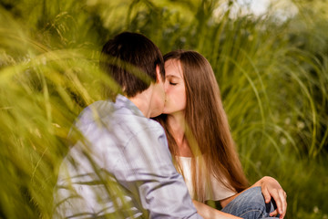 Couple kissing each other behind bushes