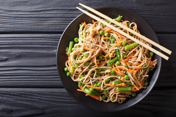 Japanese soba salad with vegetables and sesame close-up on the table. horizontal top view