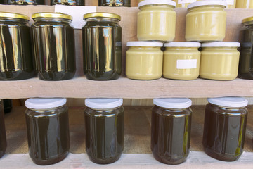 Vases with honey and tahini on the shelf of a store