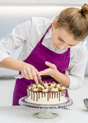 woman decorating chocolate cake in the kitchen