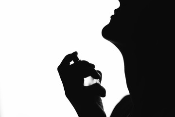 silhouette of a woman who holds the scent in her hand, fashion and beauty,black and white photo