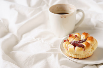 coffee cup and bread in bed, cozy breakfast