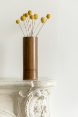Fototapeta na wymiar Billy Buttons in Wooden Vase on Marble Foyer Table