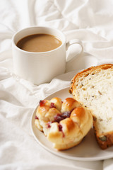 coffee cup and bread in bed, cozy breakfast