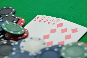 A royal flush displayed with poker chips. Shallow depth of field