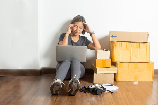 Stressed women sitting at working laptop computer from room home on wooden floor with postal parcel, Selling online ideas concept, Face expression, emotion, reaction