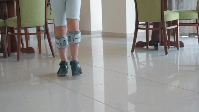 Boy walking indoor. He wearing foot drop system providing therapy with functional electrical stimulation