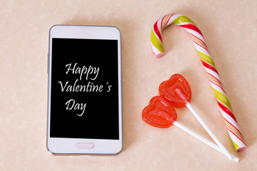 mobile phone with message of love and candies, concept of valentines