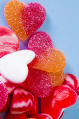 Heart shaped rubber candies on blue background