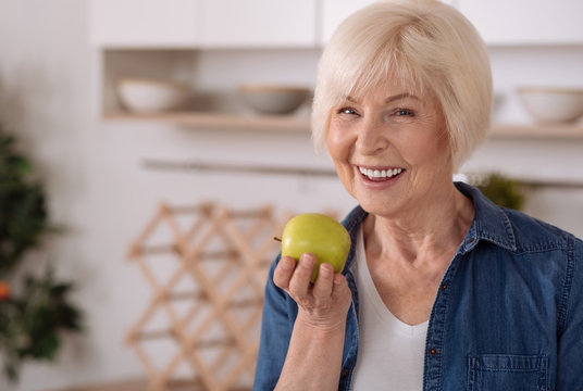 Cheerful Senior Woman Eating An Apple