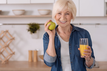 Cheerful elderly woman having a healthy breakfast