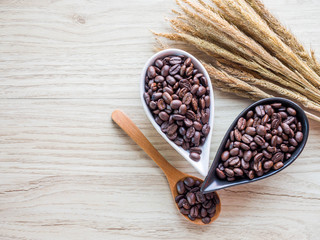 Black coffee seed in ceramic cup and wood spoon on wood floor