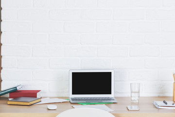 Designer workspace with empty laptop screen